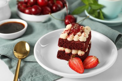 Photo of Piece of delicious red velvet cake with fresh berries served on white table, closeup