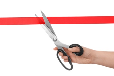 Photo of Woman cutting red ribbon with scissors on white background. Traditional ceremony