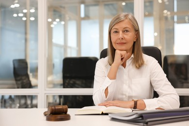 Portrait of confident lawyer working at table in office, space for text