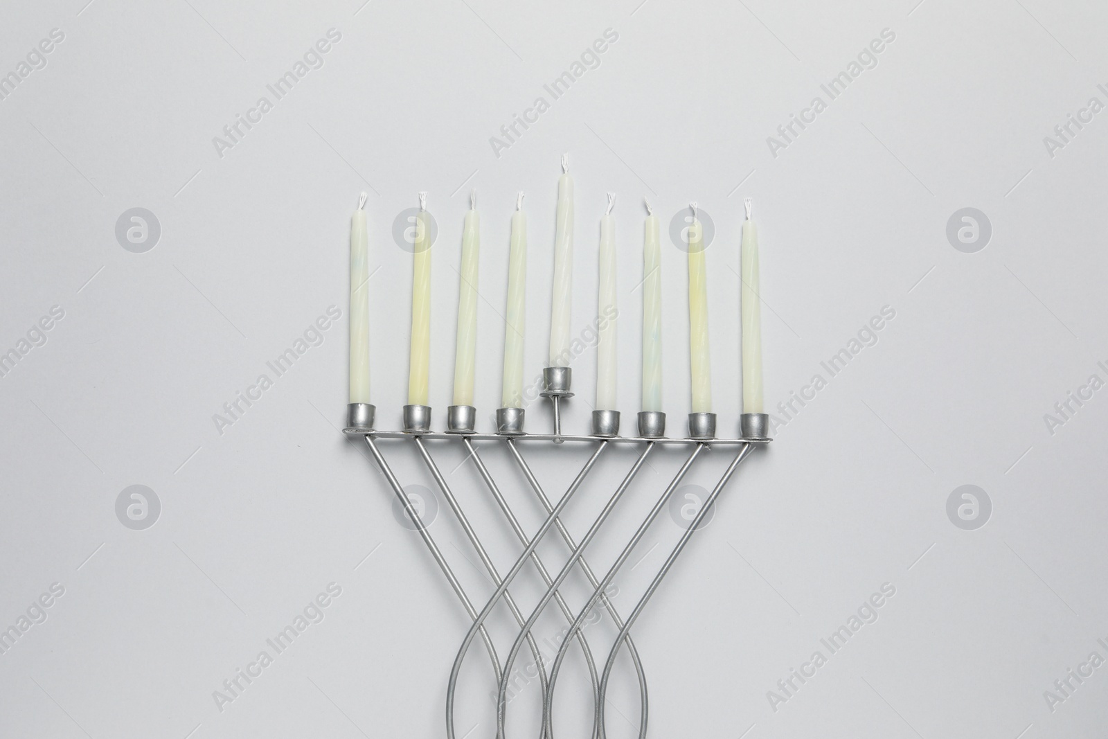 Photo of Hanukkah menorah with candles on light background, flat lay