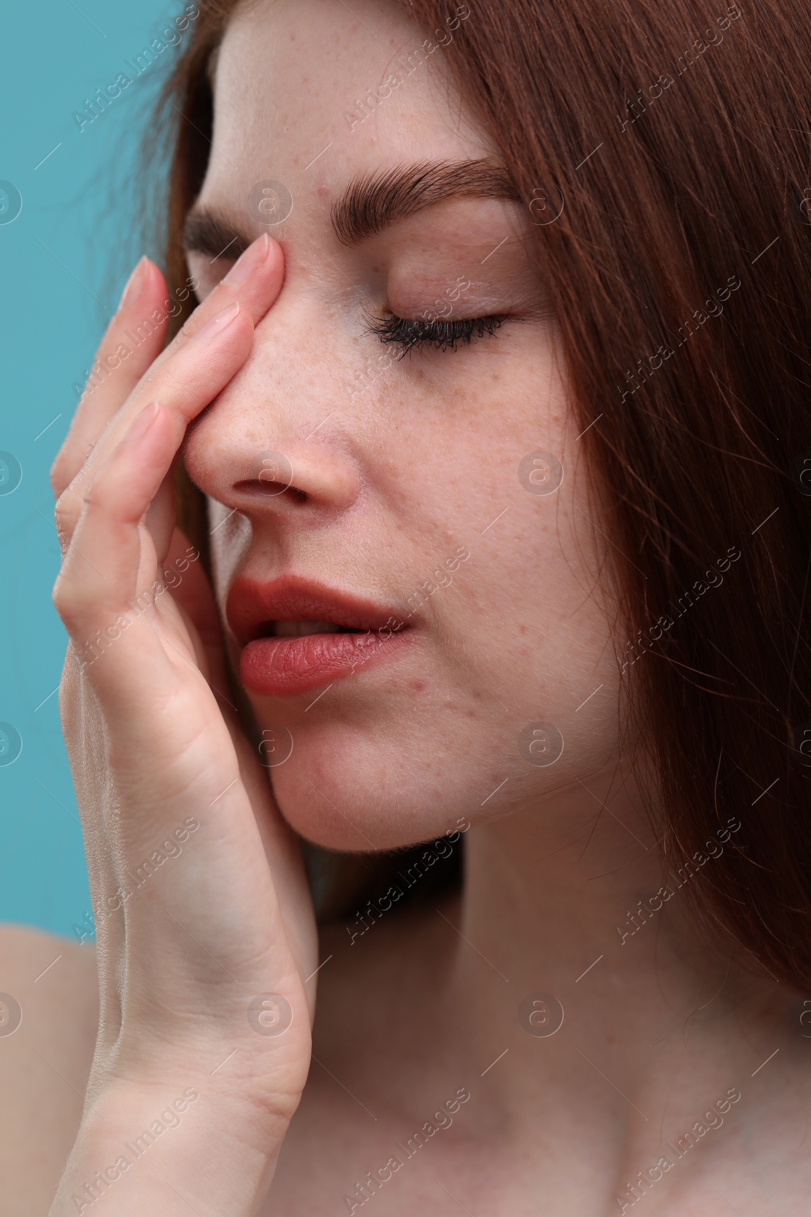 Photo of Beautiful woman with freckles on light blue background, closeup