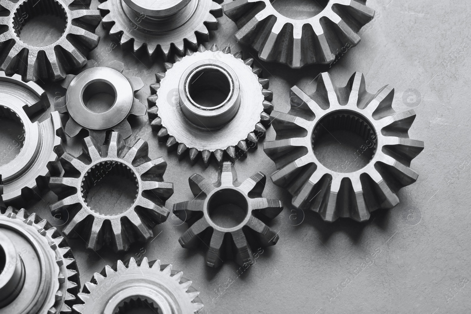 Photo of Different stainless steel gears on light grey background, above view