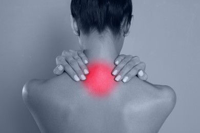 Image of Woman suffering from neck pain on grey background, closeup