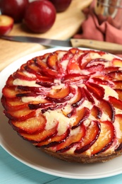 Photo of Delicious cake with plums on plate, closeup