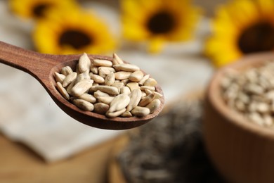 Wooden spoon with raw peeled sunflower seeds, closeup