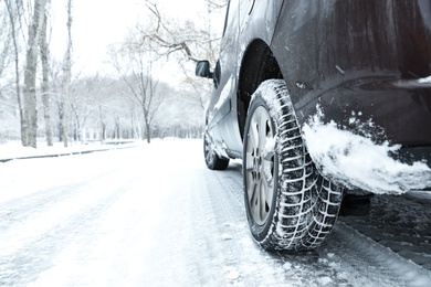 Modern car with winter tires on snowy road