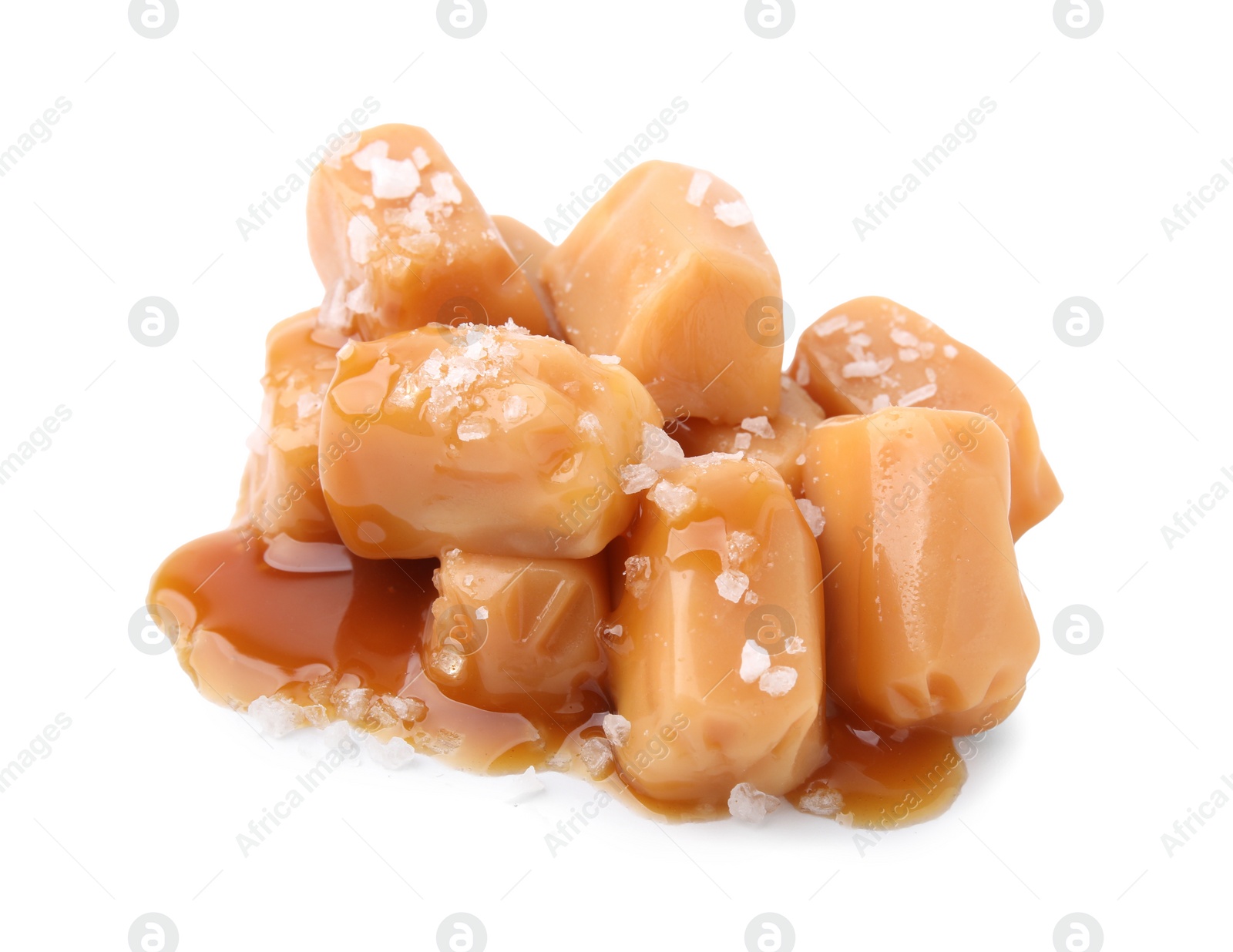 Photo of Yummy caramel candies and sea salt isolated on white