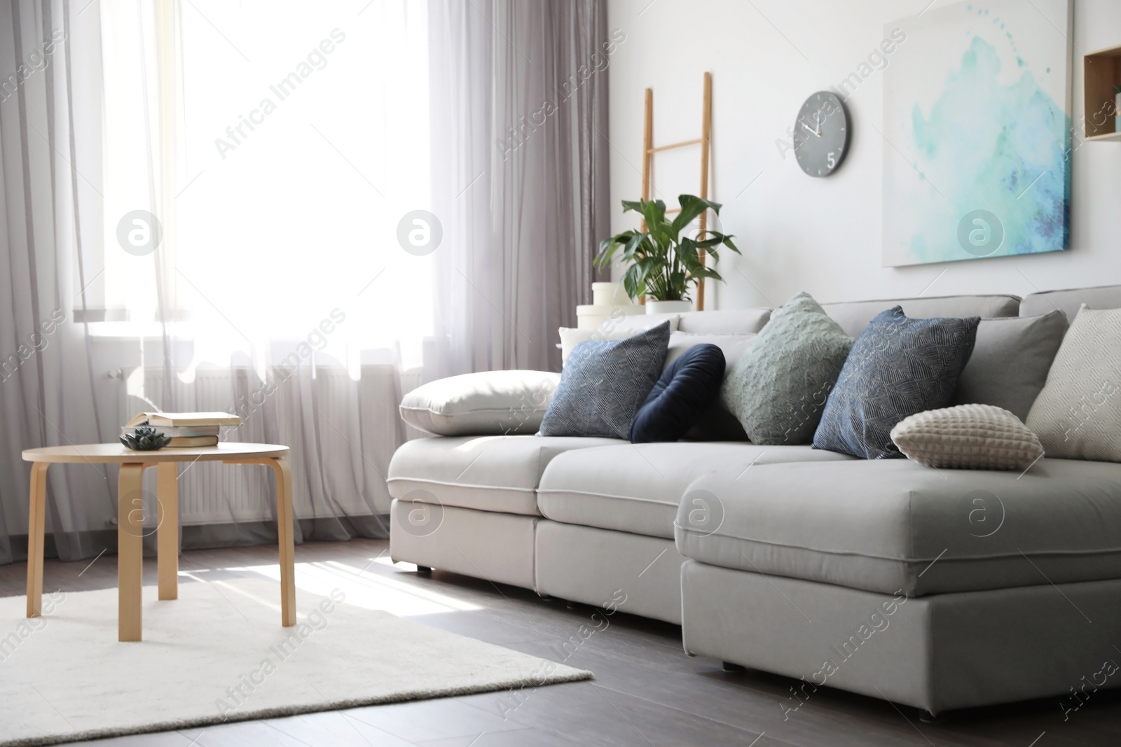 Photo of Elegant living room with comfortable sofa near window. Interior design