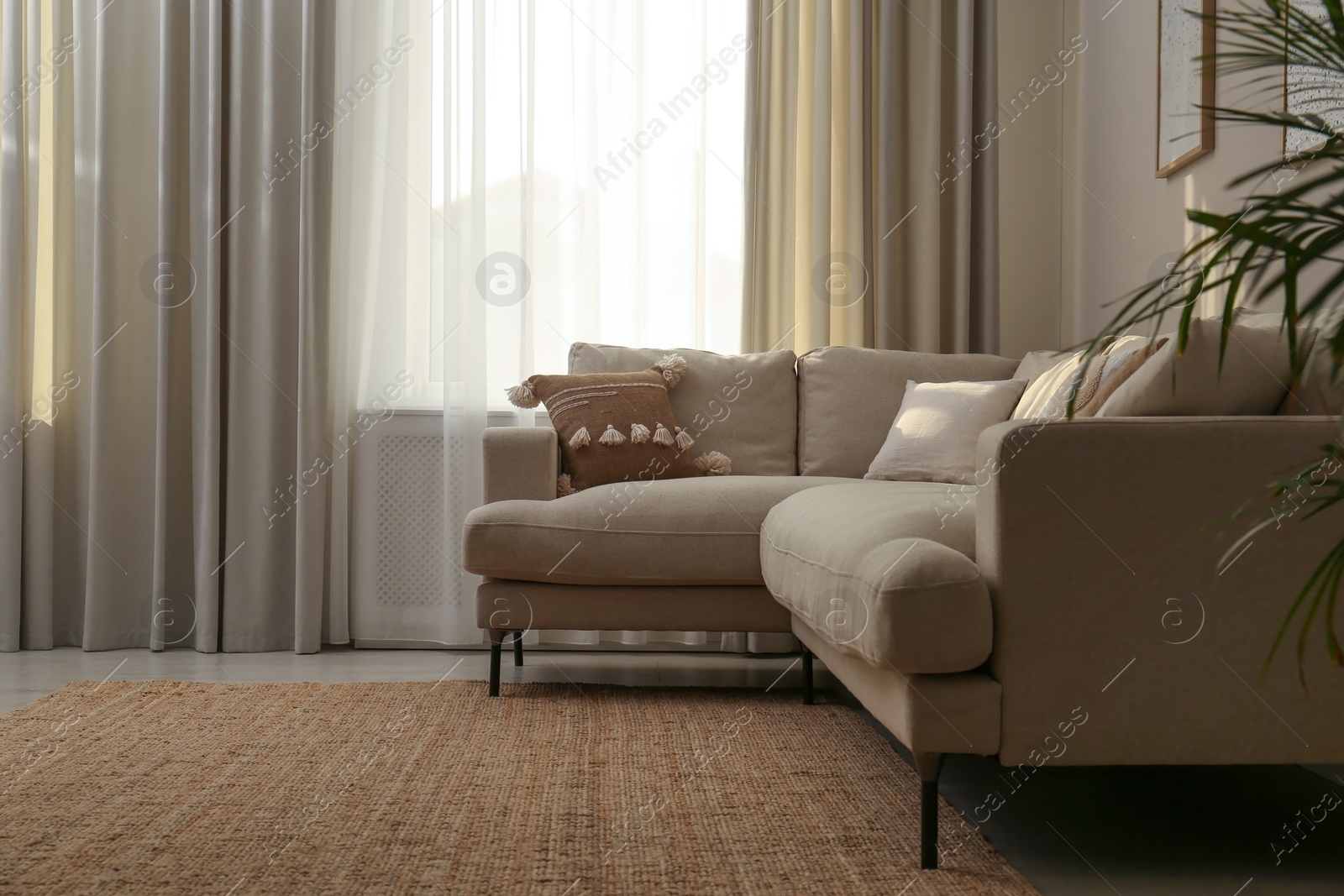 Photo of Modern comfortable sofa near window in stylish living room. Interior design