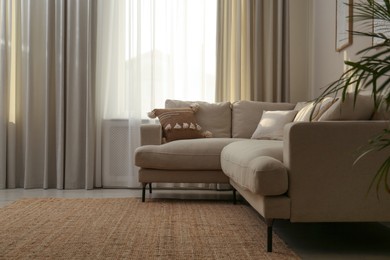 Photo of Modern comfortable sofa near window in stylish living room. Interior design