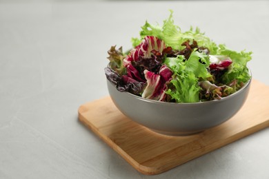 Photo of Different sorts of lettuce on light grey table. Space for text