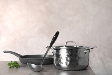 Set of clean cookware on table against color background. Space for text