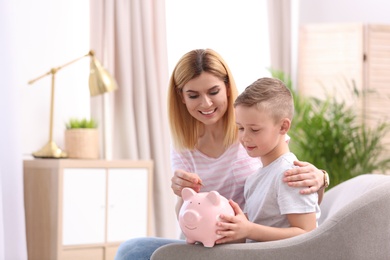 Photo of Family with piggy bank and money at home. Space for text