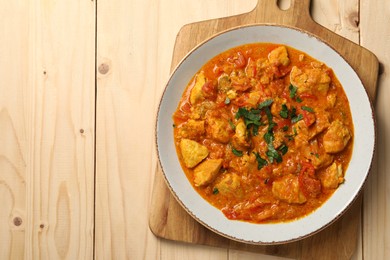 Delicious chicken curry on wooden table, top view. Space for text