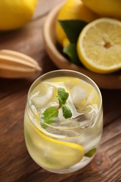 Cool freshly made lemonade and fruits on wooden table