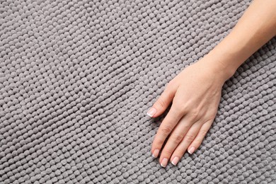 Photo of Woman touching soft grey fabric, top view. Space for text