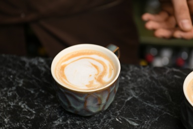 Cup of fresh aromatic coffee on table at cafe