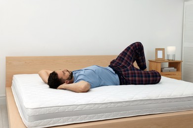 Photo of Man sleeping on bed with comfortable mattress at home