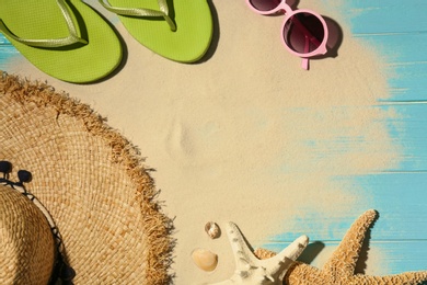 Photo of Flat lay composition with beach objects, sand and space for text on wooden background