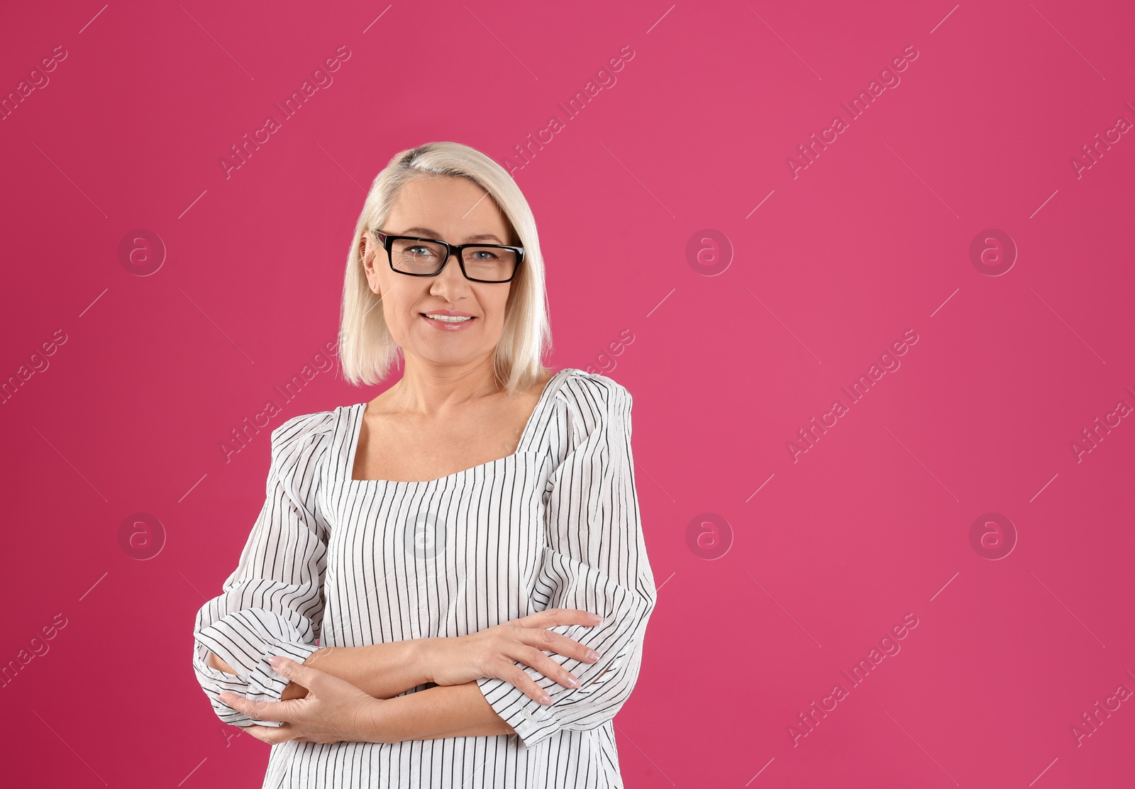 Photo of Portrait of beautiful mature woman with glasses on pink background. Space for text