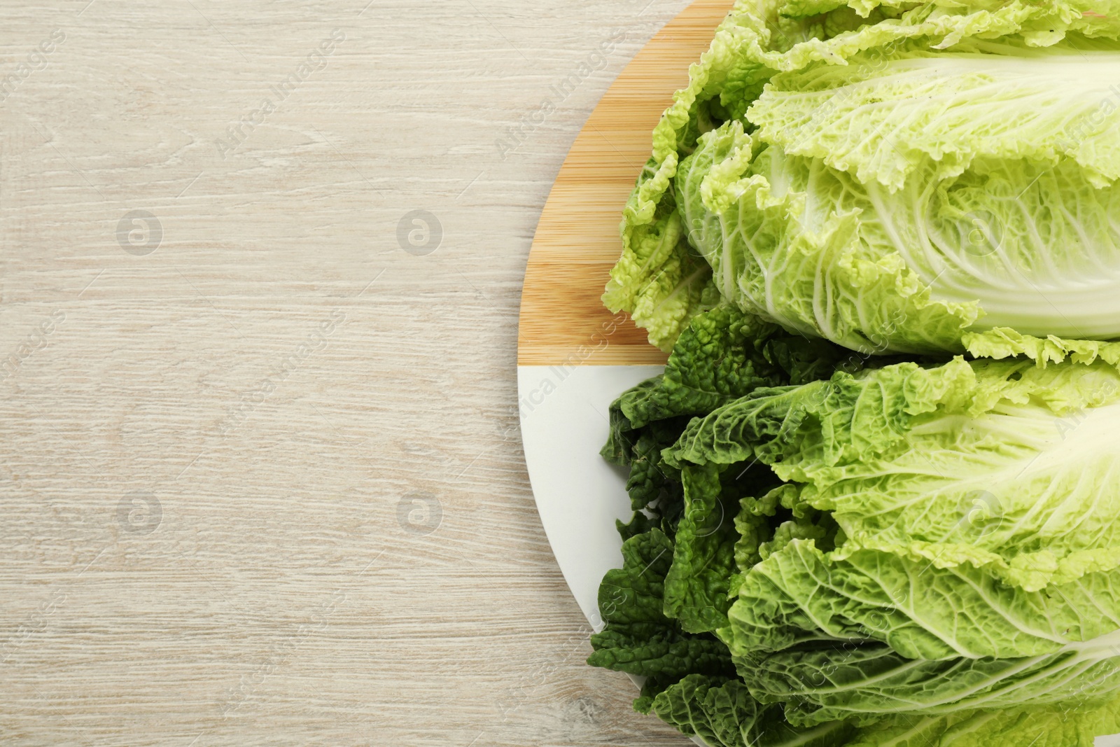 Photo of Fresh ripe Chinese cabbages on white wooden table, top view. Space for text