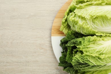 Fresh ripe Chinese cabbages on white wooden table, top view. Space for text