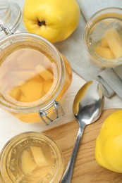 Delicious quince drink, fresh fruits and spoon on table, top view