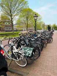 Many different bicycles parked on city street