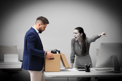 Boss dismissing young man from work in office