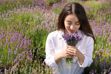 Photo of Young woman with lavender bouquet in field on summer day