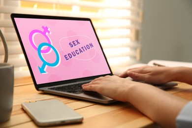 Image of Sex education program. Teenage girl using modern laptop at wooden table, closeup