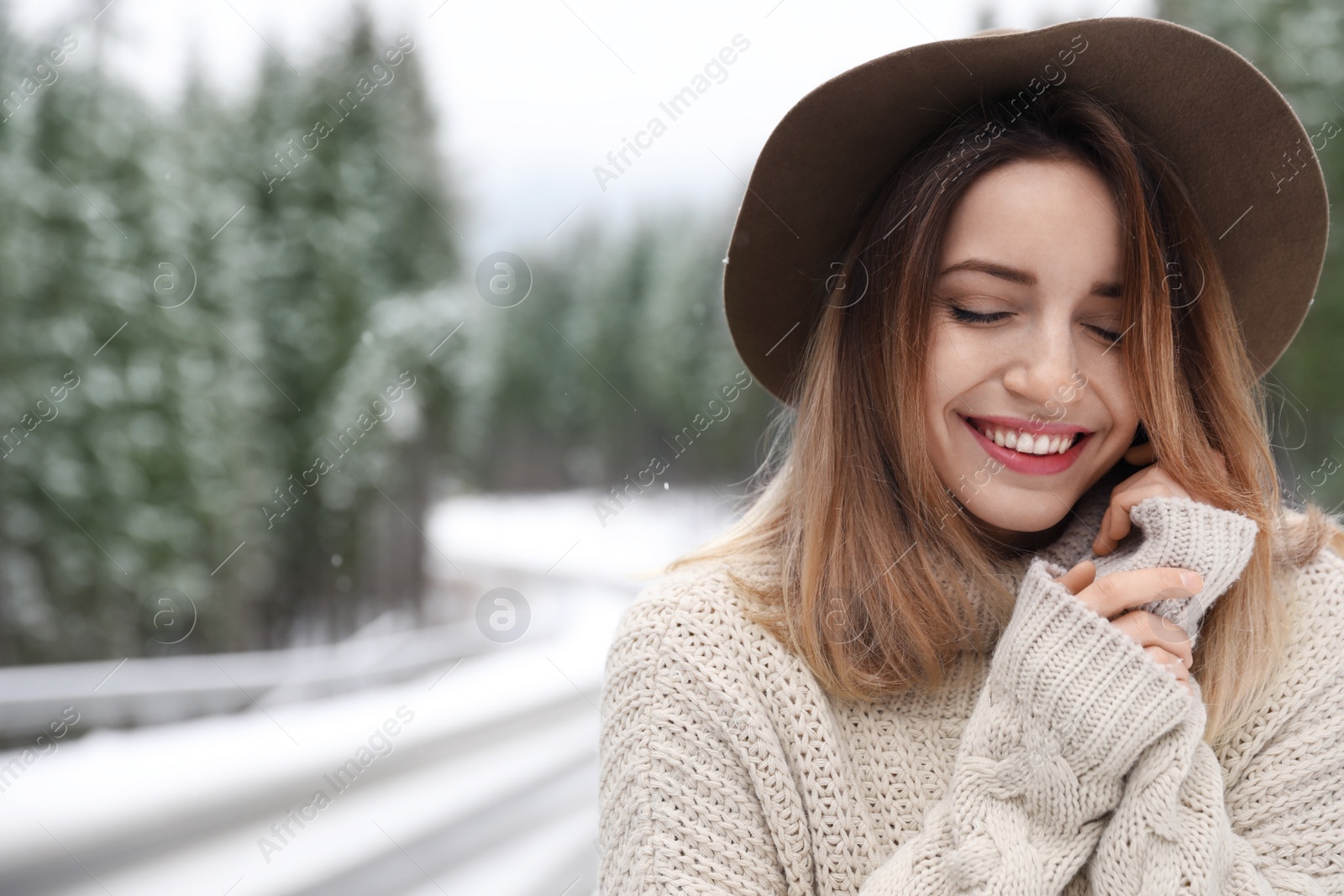 Photo of Young woman outdoors on snowy day, space for text. Winter vacation