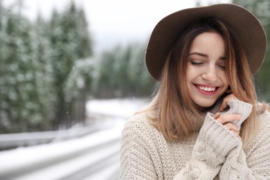 Photo of Young woman outdoors on snowy day, space for text. Winter vacation