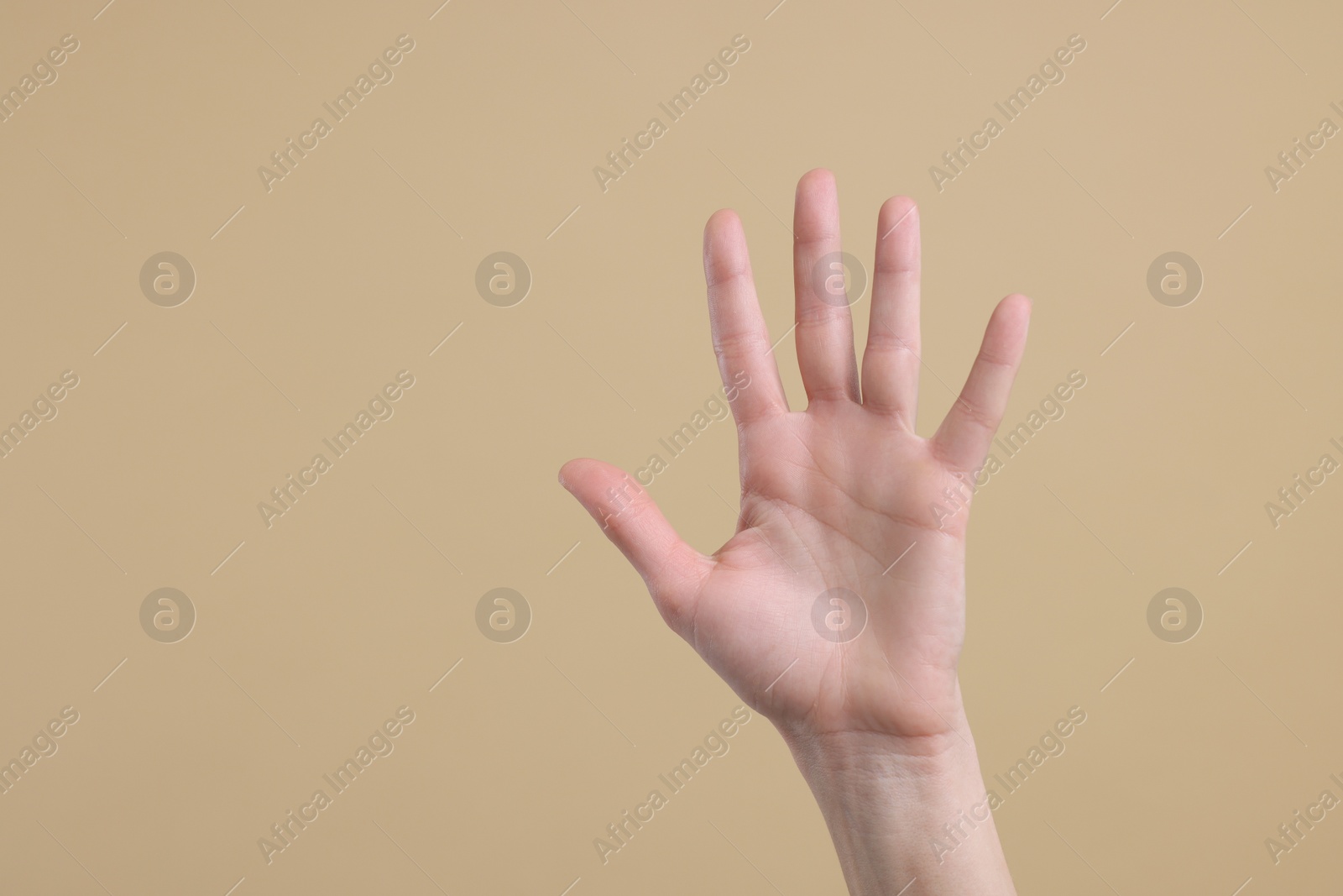 Photo of Woman giving high five on light brown background, closeup. Space for text