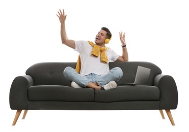 Man with laptop listening to music on comfortable grey sofa against white background