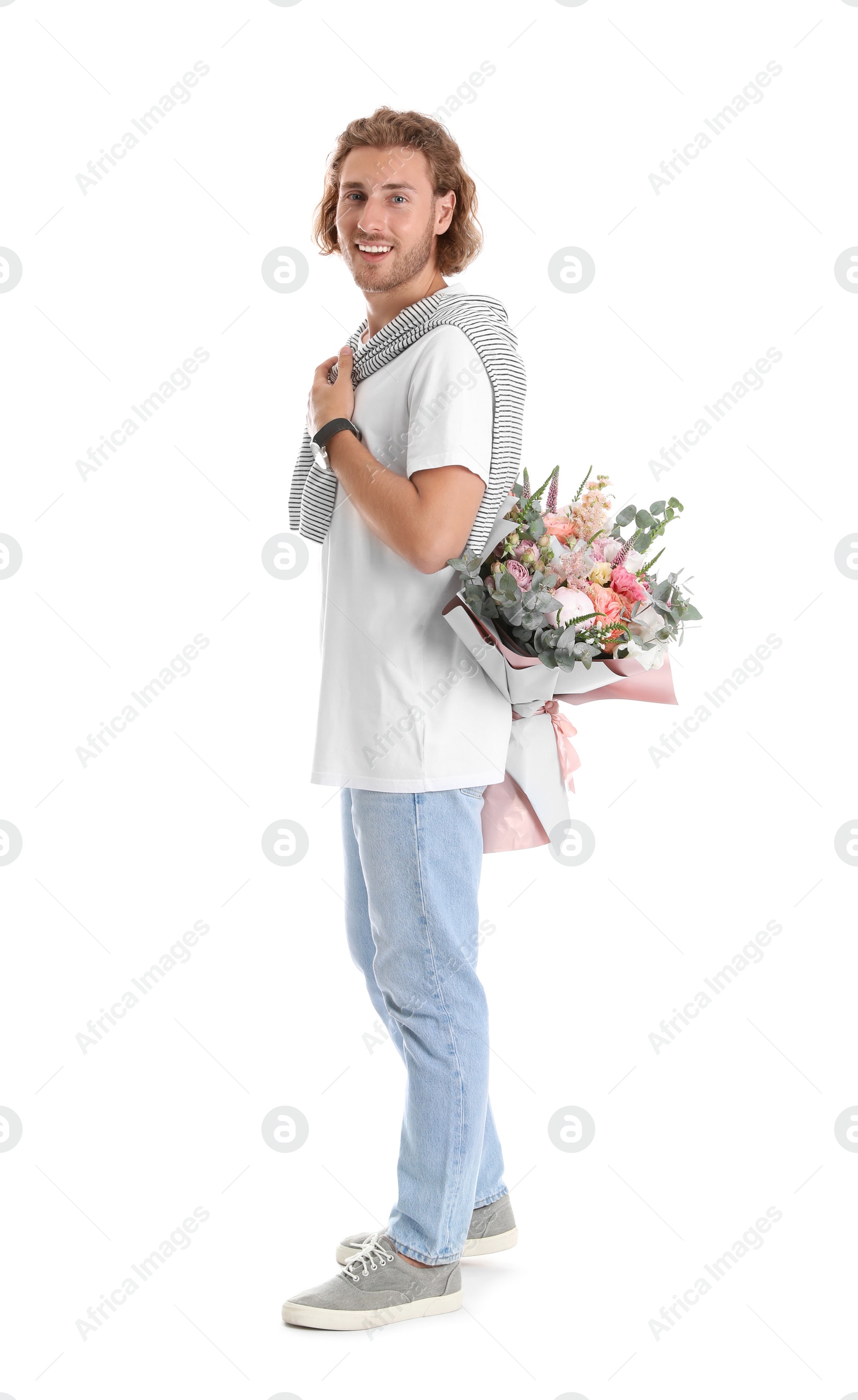 Photo of Young handsome man hiding beautiful flower bouquet behind his back on white background