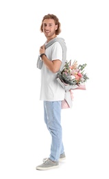 Young handsome man hiding beautiful flower bouquet behind his back on white background