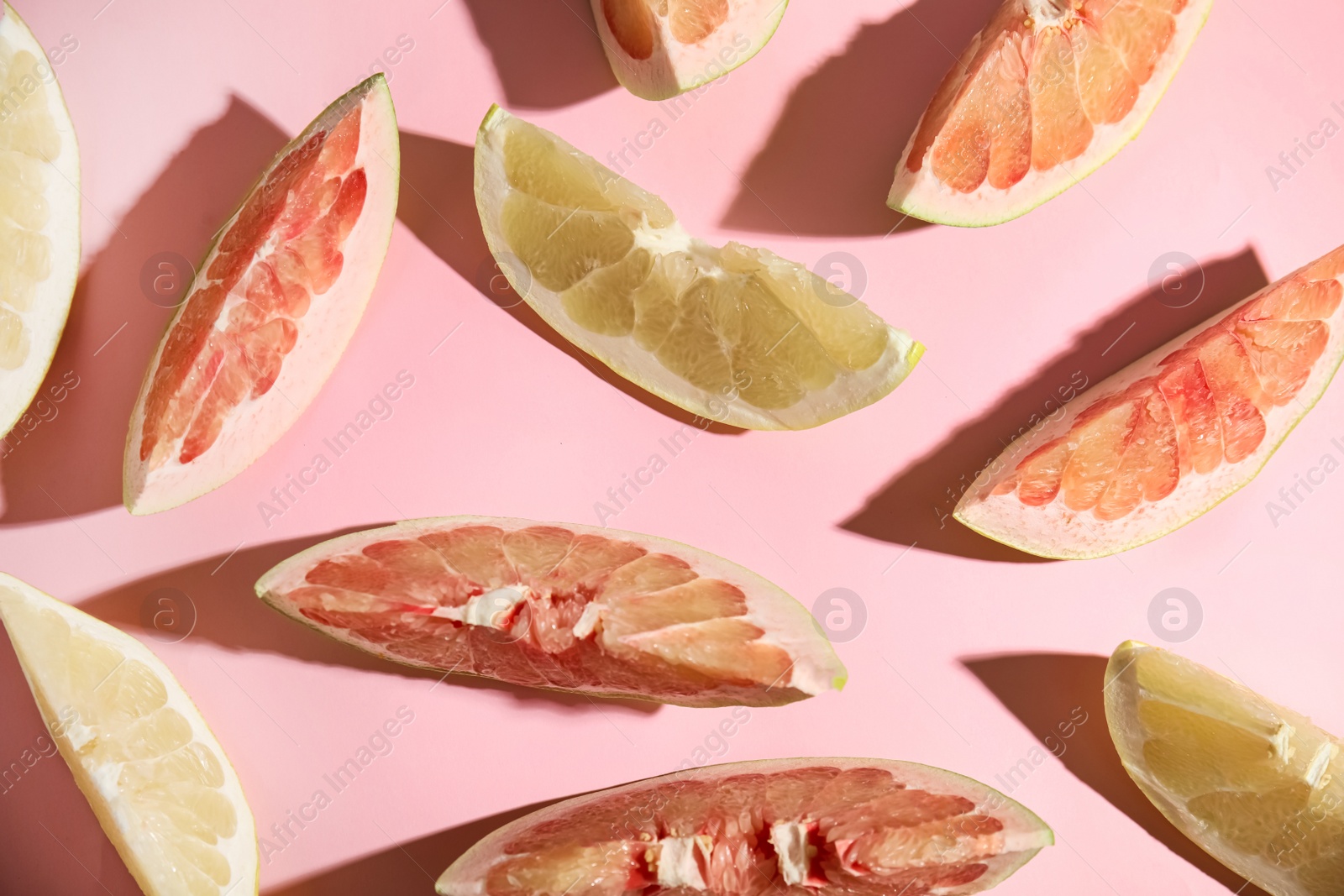 Photo of Slices of different ripe pomelos on pink background, flat lay