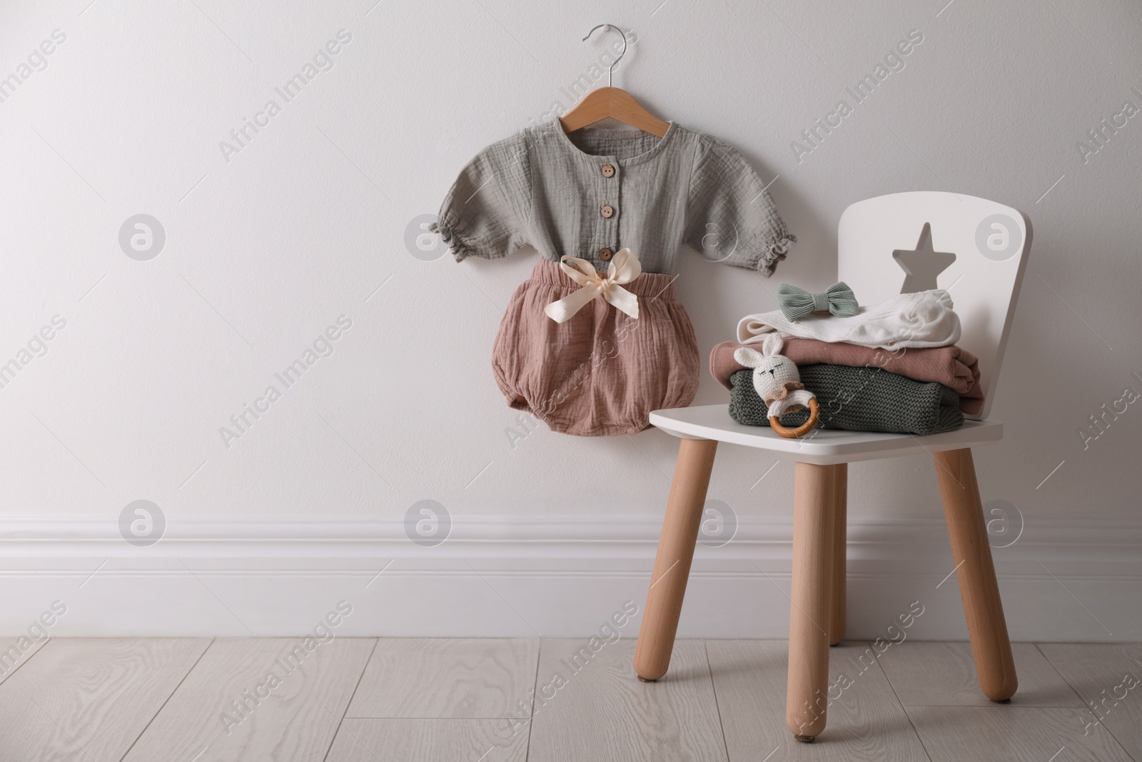 Photo of Cute children's clothes and shoes in room. Space for text