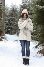 Young woman in conifer forest on snowy day. Winter vacation