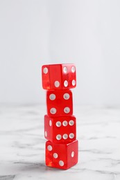 Many stacked red dices on white marble table