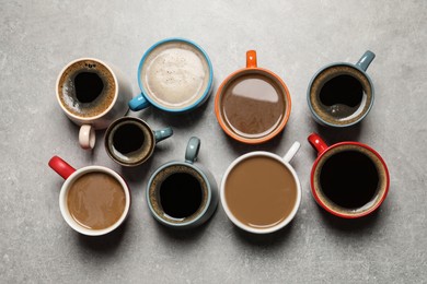 Cups of fresh aromatic coffee on light grey table, flat lay