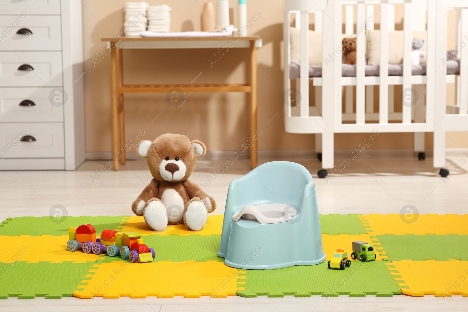 Photo of Light blue baby potty and toys in room. Toilet training