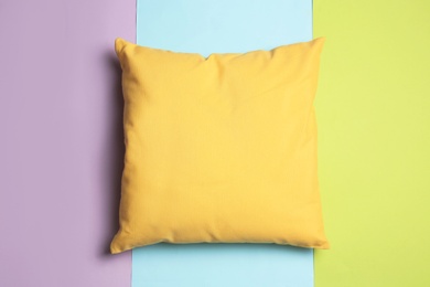 Soft decorative pillow on color background, top view