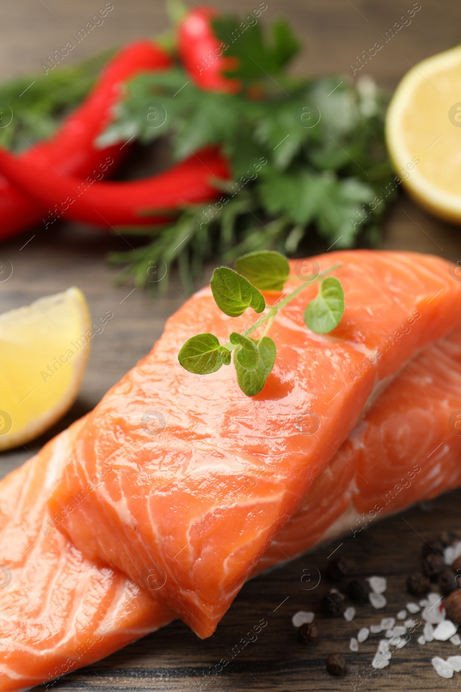 Photo of Fresh salmon and ingredients for marinade on wooden table, closeup