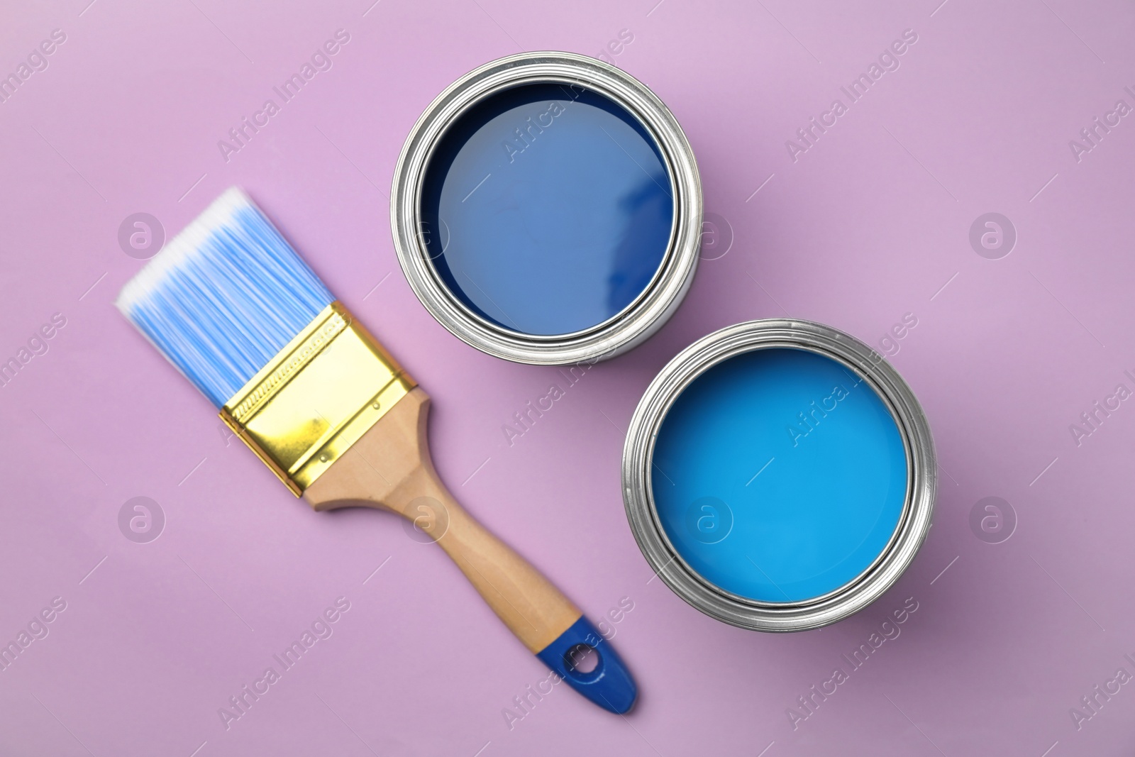 Photo of Flat lay composition with open cans of paint on color background