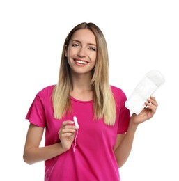 Happy young woman with disposable menstrual pad and tampon on white background