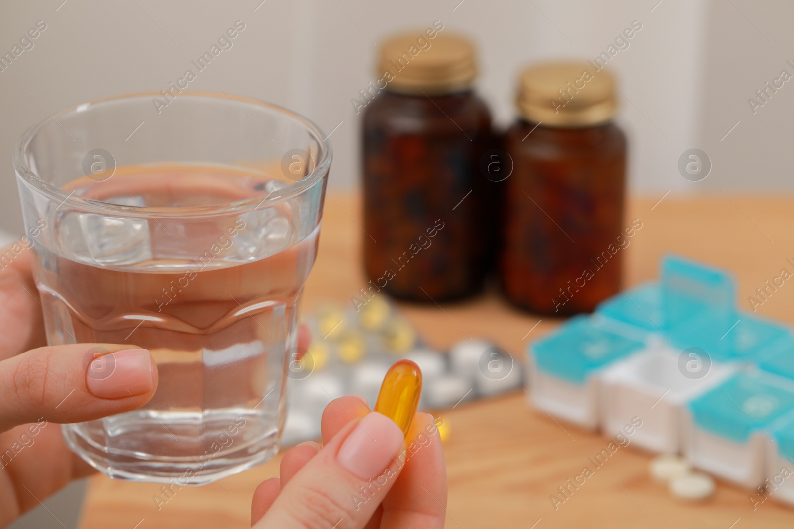 Photo of Woman holding glass of water and pill, closeup. Space for text