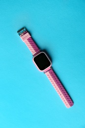 Photo of Trendy smart watch for kids on light blue background, top view