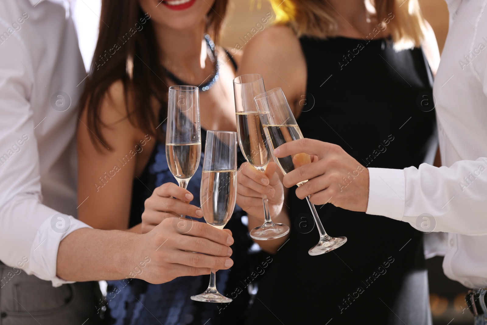 Photo of Friends clinking glasses with champagne at party, closeup